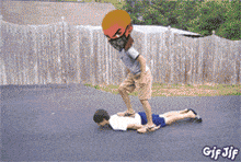 a gif of a person laying on another person 's back with a fence in the background