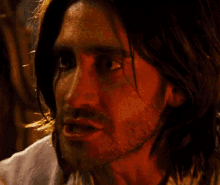a man with long hair and a beard is looking at the camera