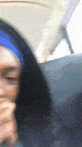 a blurry picture of a woman wearing a blue headband and a black hoodie