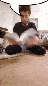 a man sitting on the floor reading a book with a speech bubble above him