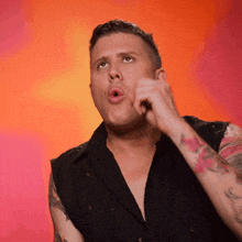 a man with a tattoo on his arm is making a face