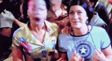 two women are posing for a picture with one wearing a shirt with a star on it .
