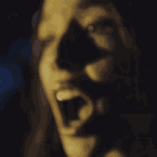 a close up of a woman 's face with her eyes closed in a dark room