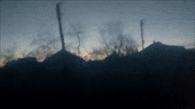 a blurry picture of a sunset with houses in the foreground