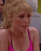 a woman in a pink tank top is crying with tears running down her face