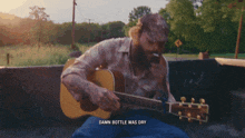 a man playing a guitar with the words damn bottle was dry underneath him