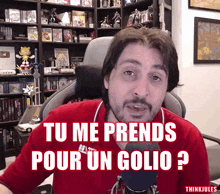 a man in a red shirt with the words tu me prends pour un golio written on it