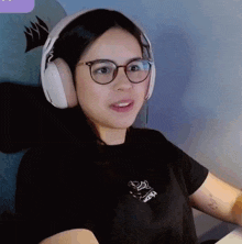 a woman wearing glasses and headphones has a tattoo on her arm that says mcm