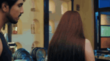 a man and a woman looking at each other in a room