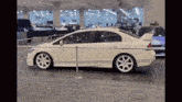 a white car is parked behind a metal barrier