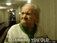 an elderly woman is making a funny face and saying `` got damn you old ''