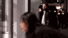 a man with a beard is standing next to a woman in a crowded street .