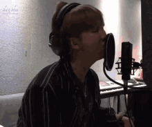 a man is singing into a microphone while wearing headphones .