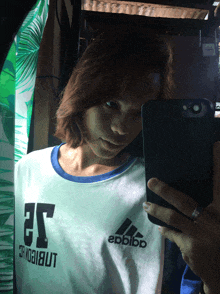 a woman is taking a selfie with her phone while wearing a shirt that says epbibo