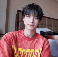 a young man wearing a red shirt that says decode
