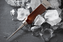 a knife with a wooden handle is laying on ice