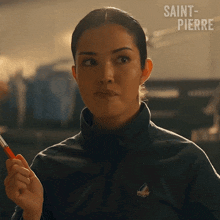 a woman in a saint pierre jacket holds a pen in her hand