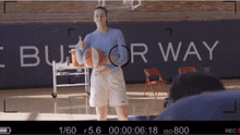 a basketball player giving a thumbs up in front of a wall that says " but for way "