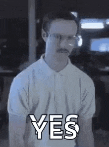 a man wearing glasses and a mustache is giving a yes sign .