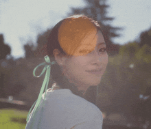 a woman with a green ribbon tied around her head