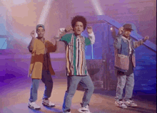 a group of men are dancing together on a stage in front of a door .