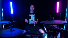 a man playing drums with a shirt that says t on it