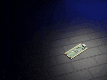 a motherboard with the numbers 88 on it sits on a black tile floor
