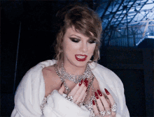 a woman with red nails is wearing a white coat