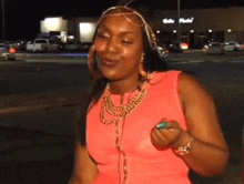 a woman in a pink dress is standing in front of a store that says belle place