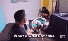 a man sitting in front of a cake with the words what a waste of cake on the bottom