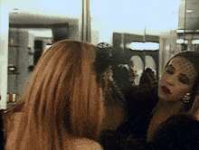 a woman is looking at herself in a mirror
