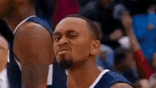 a basketball player is making a funny face during a game .
