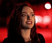 a close up of a woman 's face with a red background .