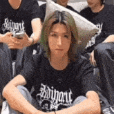 a man with long green hair is wearing a black t-shirt with the word ruinart on it .