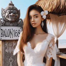 a woman in a white dress stands in front of a sign that reads balon 168