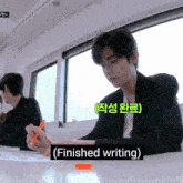 a man sitting at a desk with finished writing written on the bottom of the image