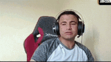 a man is wearing headphones and sitting in a chair .