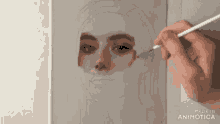 a person is painting a woman 's face on a canvas with a brush ..