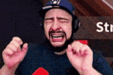 a man with a beard wearing headphones is crying