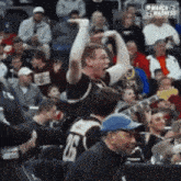 a man wearing a number 26 jersey is cheering in the stands