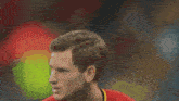 a man wearing a red shirt with a yellow stripe on the sleeve that says ' fifa '