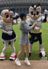 a woman standing next to two mascots one of whom has a shirt that says kirin on it