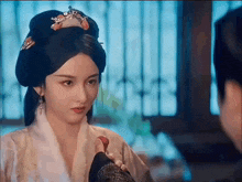 a woman in a white robe is looking at a man