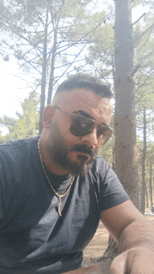 a man with a beard wearing sunglasses and a black shirt