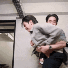 a man is carrying another man on his back and they are both smiling