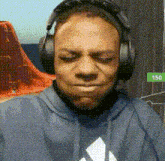 a man wearing headphones and a hoodie is making a funny face .