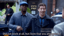 two men standing in front of a building that says ' did not work at all but i love that you attempted it ' on it
