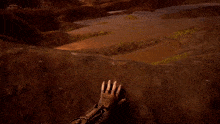 a person 's hand is pointing at a puddle in a video game