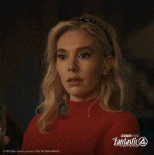 a woman in a red sweater is holding a glass of water in front of a poster for the fantastic 4 first steps