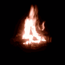 a large fire burning in the dark with a black background